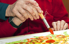 Ältere Hand beim Malen, von jüngerer Hand geführt   